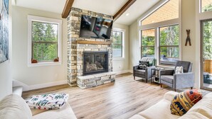 A spacious living room with a stone fireplace, large windows, and a cozy seating area. - Government Camp Vacation Rental w/ Private Hot Tub (Government Camp)