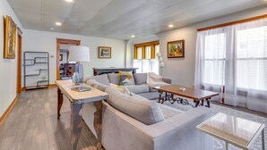 A modern living room with a sofa set, a coffee table, and a bookshelf. - Stillwater Home - Walk to Boone Pickens Stadium! (Stillwater)