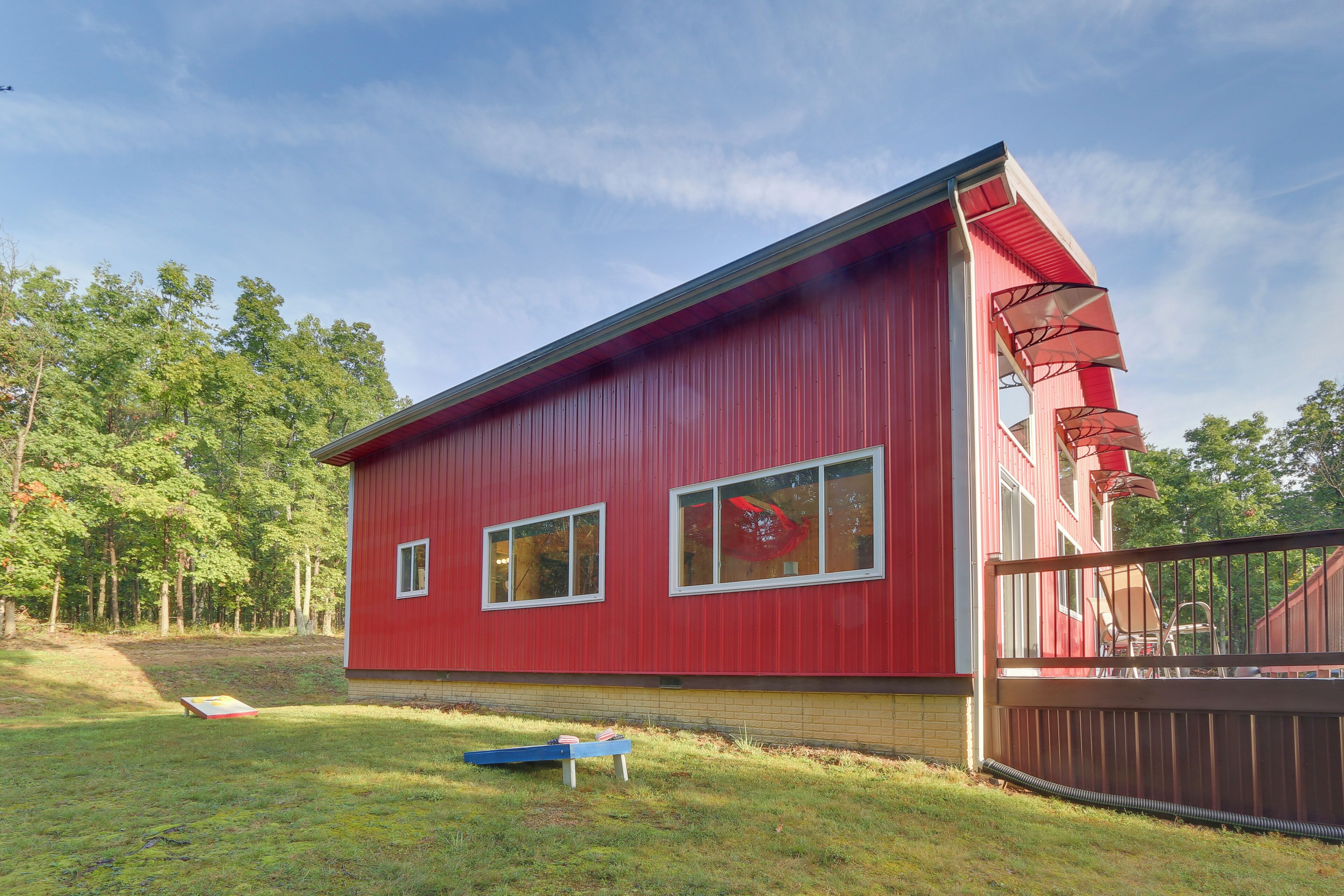 A red building with large windows and a fenced yard.