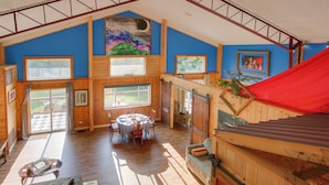 Un ambiente spazioso con soffitto alto, pareti in legno e ampie finestre.