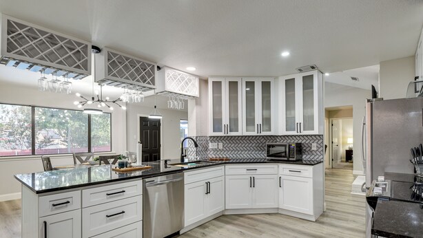 A modern kitchen with white cabinetry, a black countertop, and a herringbone-patterned backsplash. - 11 Mi to Six Flags! Poolside Oasis in Bedford (Bedford)