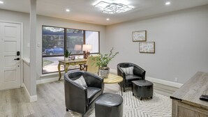 A modern living room with a large window, a round coffee table, and two leather armchairs. - 11 Mi to Six Flags! Poolside Oasis in Bedford (Bedford)