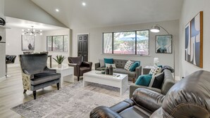 A spacious living room with a modern ceiling fan, a white coffee table, and leather sofas. - 11 Mi to Six Flags! Poolside Oasis in Bedford (Bedford)