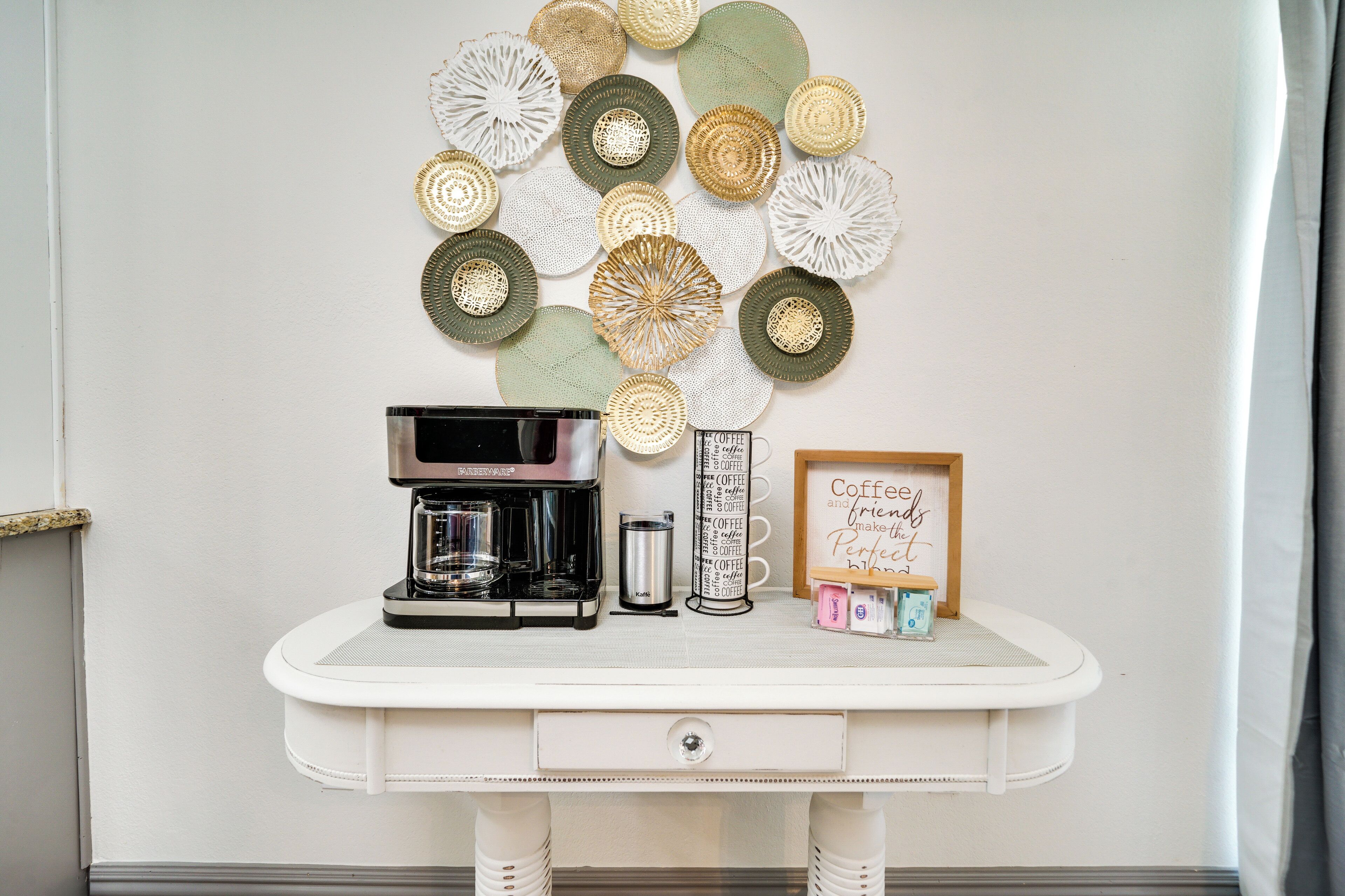 A coffee station with a coffee maker, a coffee mug, and a sign that says "Coffee is friends make perfect."