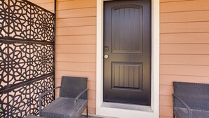 A dark front door with a decorative panel to the left, and two wicker chairs positioned outside. - Dolores Townhome w/ Mountain Views: Near River! (Dolores)