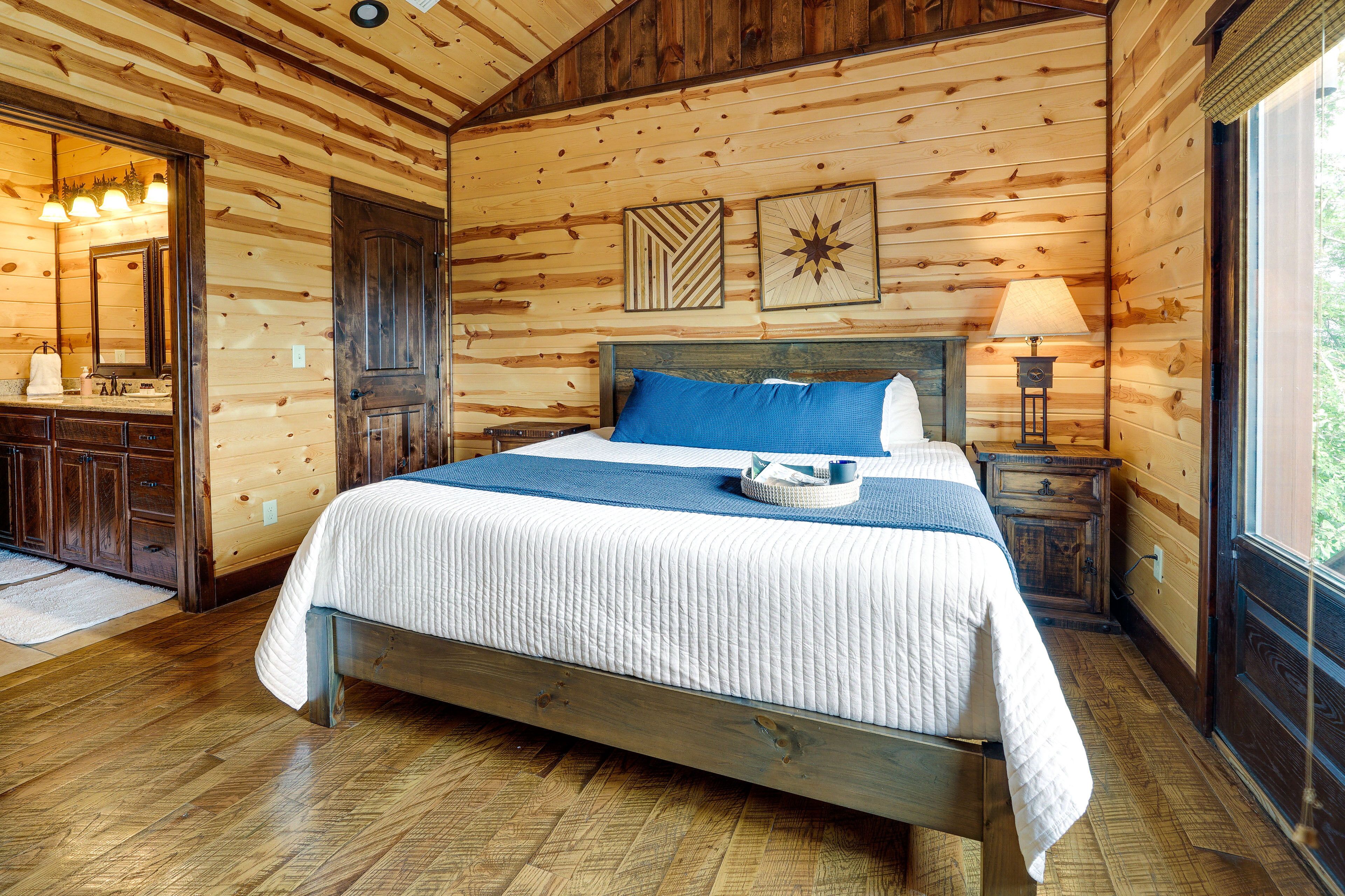 A wooden-paneled bedroom with a bed, a nightstand, a lamp, and a mirror.