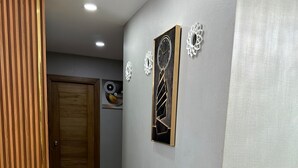 Ein Flur mit einer Holzwand, einer Tür und drei Wanduhren.
