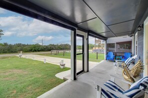 A covered outdoor seating area with a view of the surrounding landscape. - Relax at Heron Bay Cottage in Rockport, Texas! (Rockport)