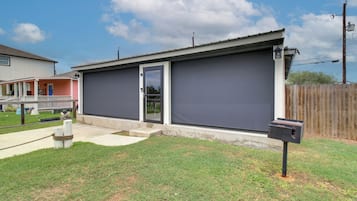 A residential garage with a sliding door, a mailbox, and a wooden fence in the background.