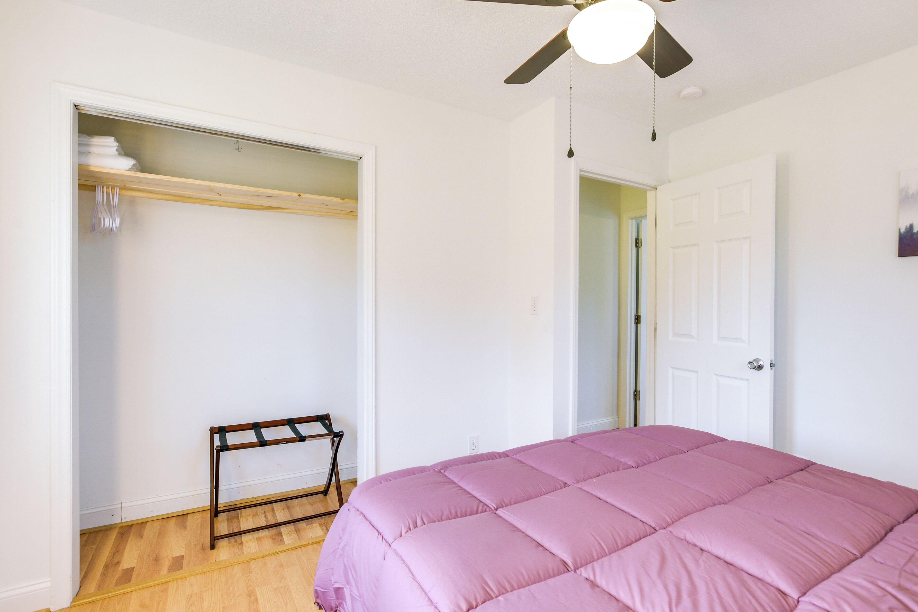A bedroom with a bed, a wardrobe, and a ceiling fan.