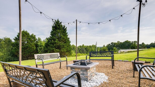 Un espacio al aire libre con bancos y una chimenea.