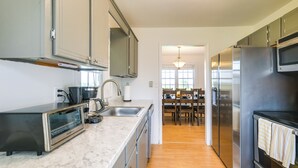 Una cocina moderna con horno empotrado, refrigerador de acero inoxidable y microondas.