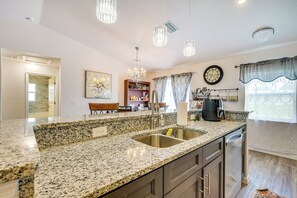 A kitchen with granite countertops, stainless steel appliances, and pendant lighting. - Newly-built Inverness Home Rental w/ Yard + Patio! (Inverness)
