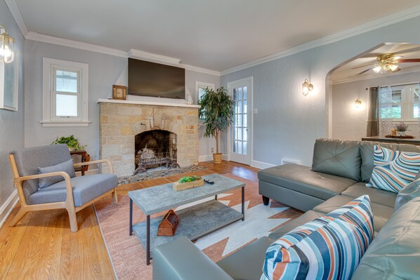 A living room with a stone fireplace, a sofa, a chair, and a coffee table.
