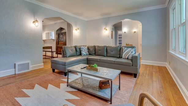 A modern living room with a sectional sofa, a coffee table, and a rug. - Vacation Rental Near University of Illinois (Champaign)