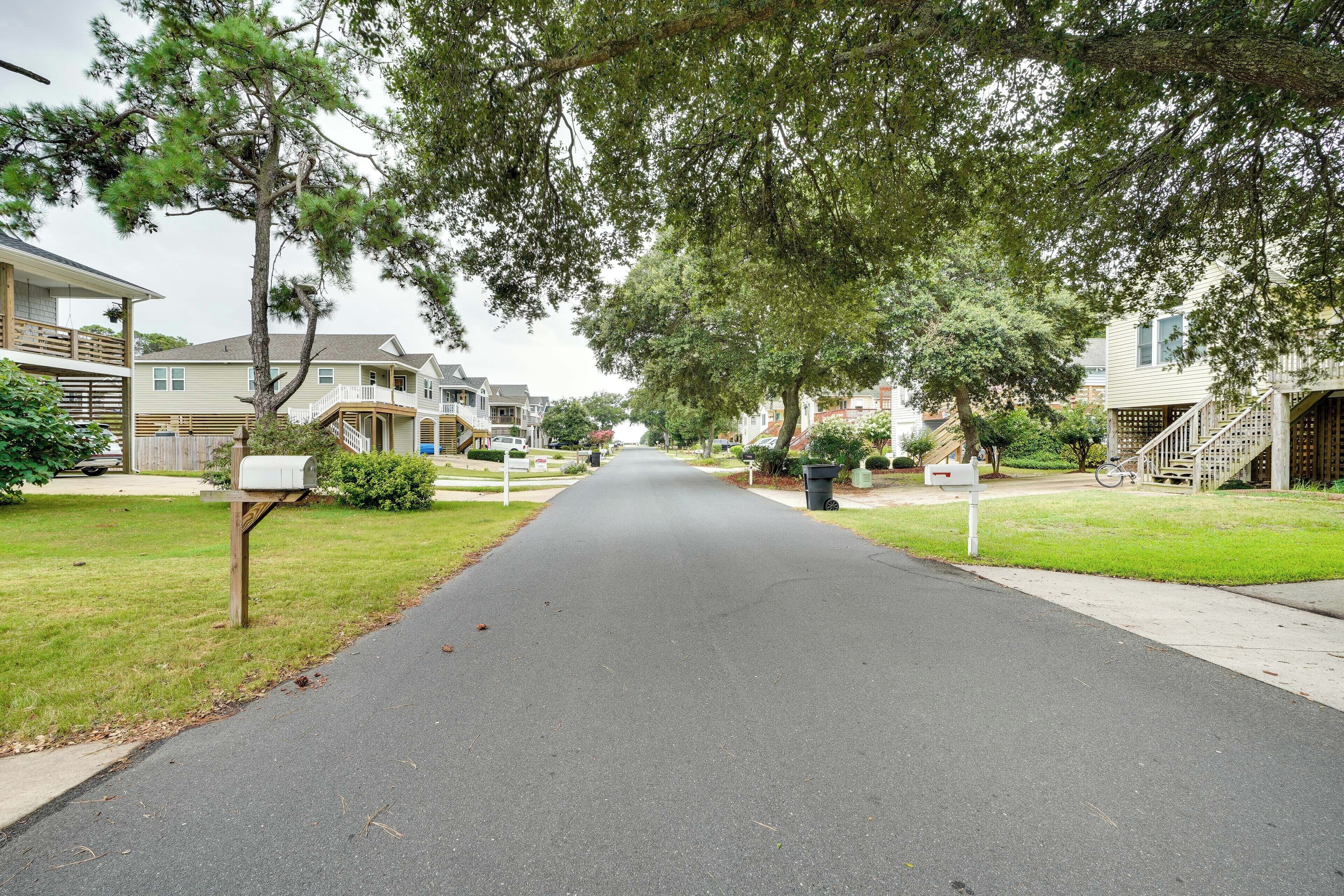 A residential street with houses, a mailbox, and a bicycle.