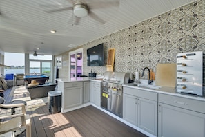 A modern kitchen with a large island, stainless steel appliances, and a view of the water. - Weymouth Waterfront Getaway w/ Swim Spa & Hot Tub (North Weymouth)