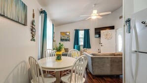 A dining area with a white table and chairs, a ceiling fan, and a window with blue curtains. - Lakefront Keystone Heights Home w/ Boat Ramp! (Keystone Heights)