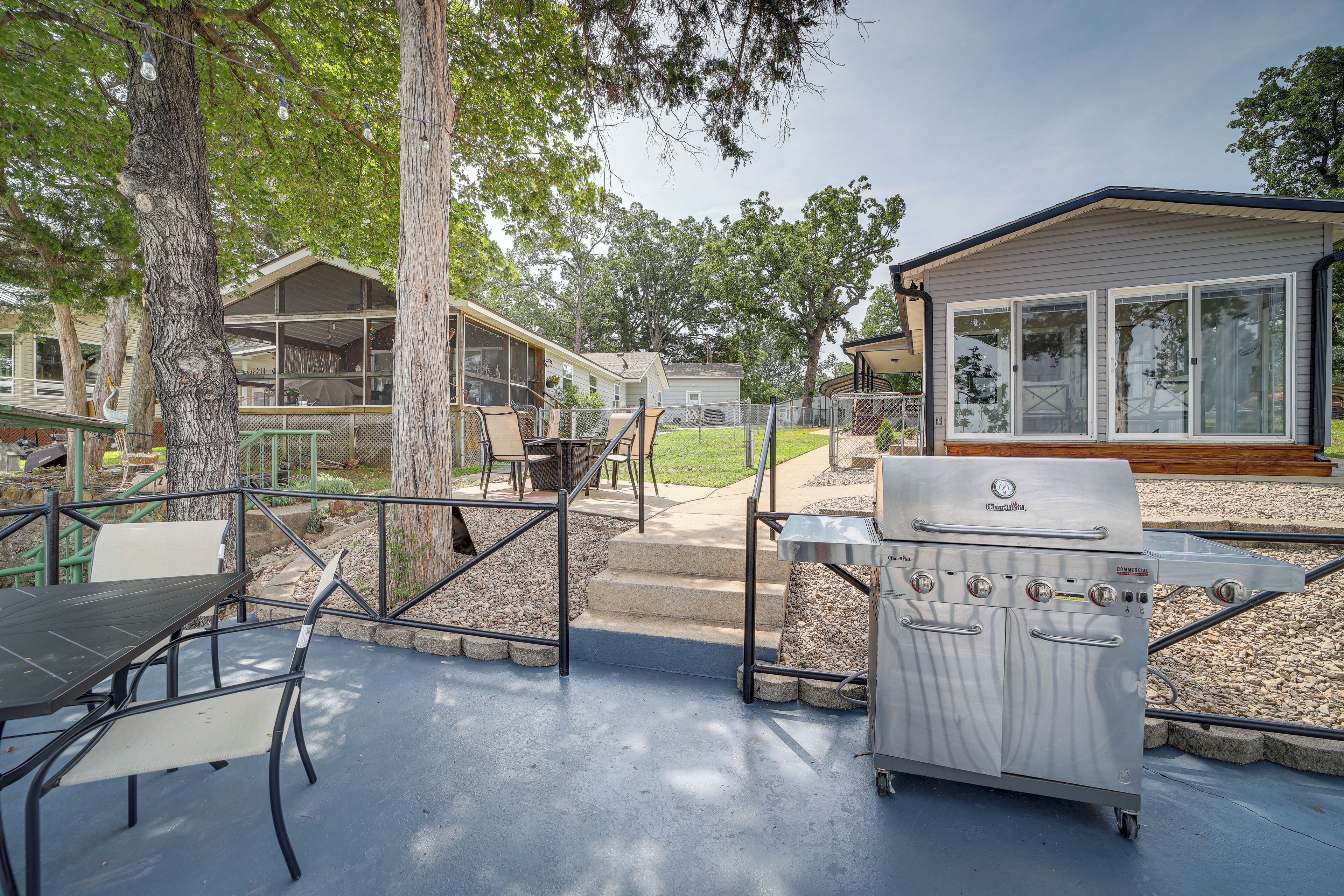 Eine Terrassenfläche mit Grill, Gartenmöbeln und Blick auf ein Wohngebäude.