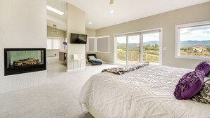 A bedroom with a large bed, a ceiling fan, a TV mounted on the wall, and a view of the outdoors through a sliding door. - Prescott Gem: Hot Tub & Mtn Views, 7 Mi to Dtwn (Prescott)