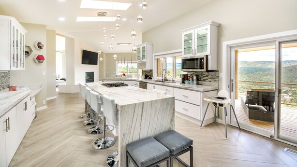 A modern kitchen with a large island, bar stools, and a view of the outdoors. - Prescott Gem: Hot Tub & Mtn Views, 7 Mi to Dtwn (Prescott)