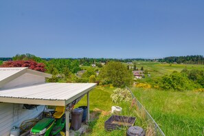 A rural landscape with a house, green tractor, and various outdoor items. - Port Angeles Apartment Near Olympic Natl Park! (Port Angeles)