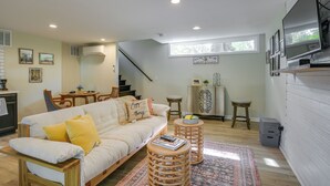 A cozy living room with a sofa, two side tables, a coffee table, and a patterned rug.