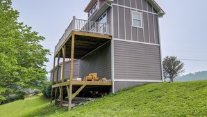 Une maison à deux étages avec un balcon et une terrasse en bois.