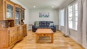 Un salon spacieux avec une table basse en bois, un canapé en cuir foncé et un grand meuble avec des portes en verre.