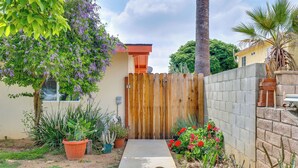 A concrete pathway leading to a wooden gate, surrounded by potted plants and flowering shrubs. - Sleek San Fernando Studio ~ 14 Mi to Universal (San Fernando)