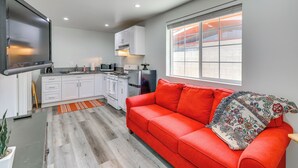 A compact living space with a kitchenette, a red sofa, and a large window. - Sleek San Fernando Studio ~ 14 Mi to Universal (San Fernando)