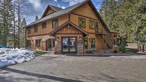 Un chalet avec une façade en bois, une entrée principale et un escalier menant à l’étage supérieur.