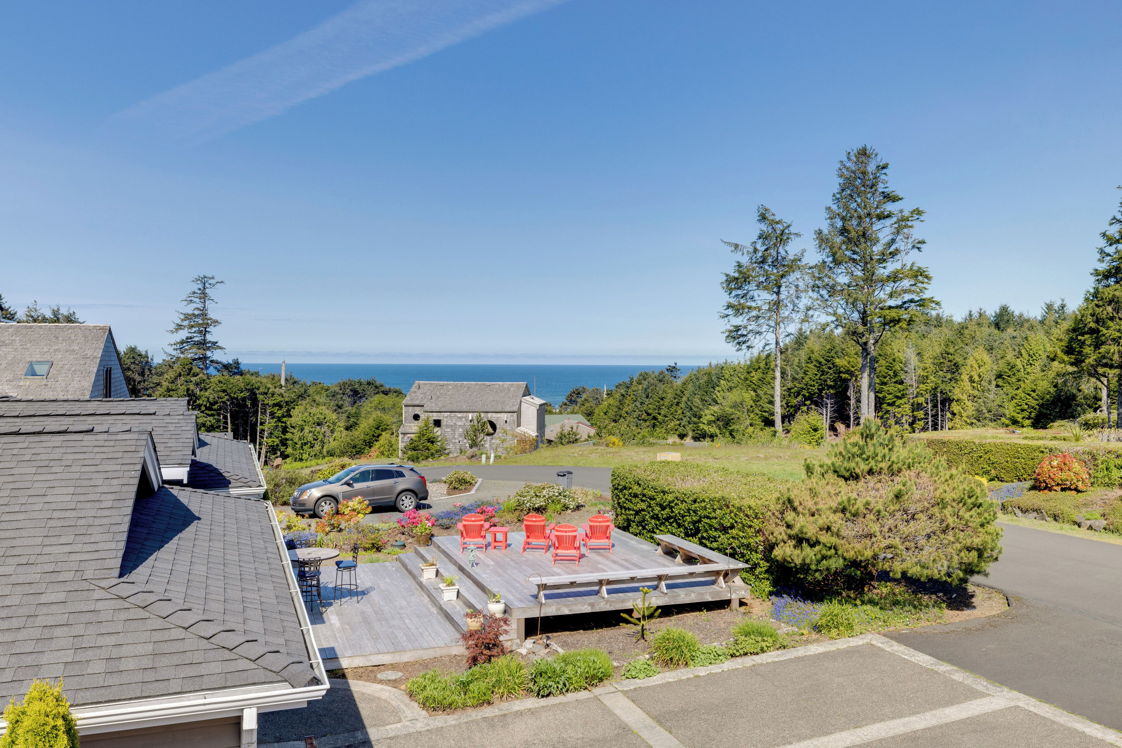 A residential property with a deck, outdoor seating, and a view of the ocean.