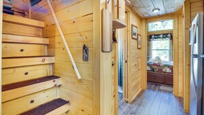 A wooden interior with a staircase, a refrigerator, and a window with curtains. - 7 Mi to Lake Lure: Mill Spring Cabin w/ Hot Tub (Mill Spring)