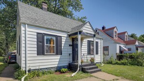 A single-story house with a front porch, a chimney, and a small garden area. - Gary Vacation Rental ~ 5 Mi to Lake Michigan! (Gary)