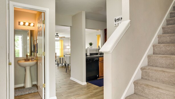 A home interior with a staircase, a kitchen, and a bathroom.