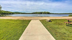 A concrete pathway leading to a lake with a picnic table on the right. - Pet-friendly Pocono Lake Cabin w/ Community Pool! (Pocono Lake)