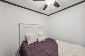 A bedroom with a bed, white walls, a ceiling fan, and a white headboard. - Cozy Snowshoe Condo Rental: Walk to Chair Lift! (Snowshoe)