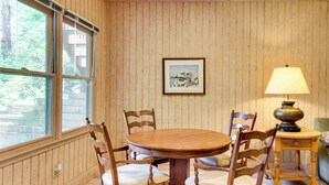 A dining area with a wooden table and chairs, a lamp, and a framed picture on the wall. - Relaxing Saluda Home Near Waterfall Trails! (Saluda)