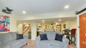 A living room with two grey sofas, a patterned rug, and a brick-patterned floor. - Rocky Vines Wine Country Retreat w/ Fire Pit (Leesburg)