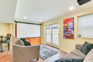A living room with a fireplace, a large window, and a flat-screen TV. - Rocky Vines Wine Country Retreat w/ Fire Pit (Leesburg)