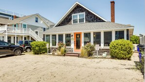 A beachfront property with a covered porch, a brick chimney, and a sandy driveway. - Dewey Beach Cottage Near Ocean - Walk to Beach! (Dewey Beach)