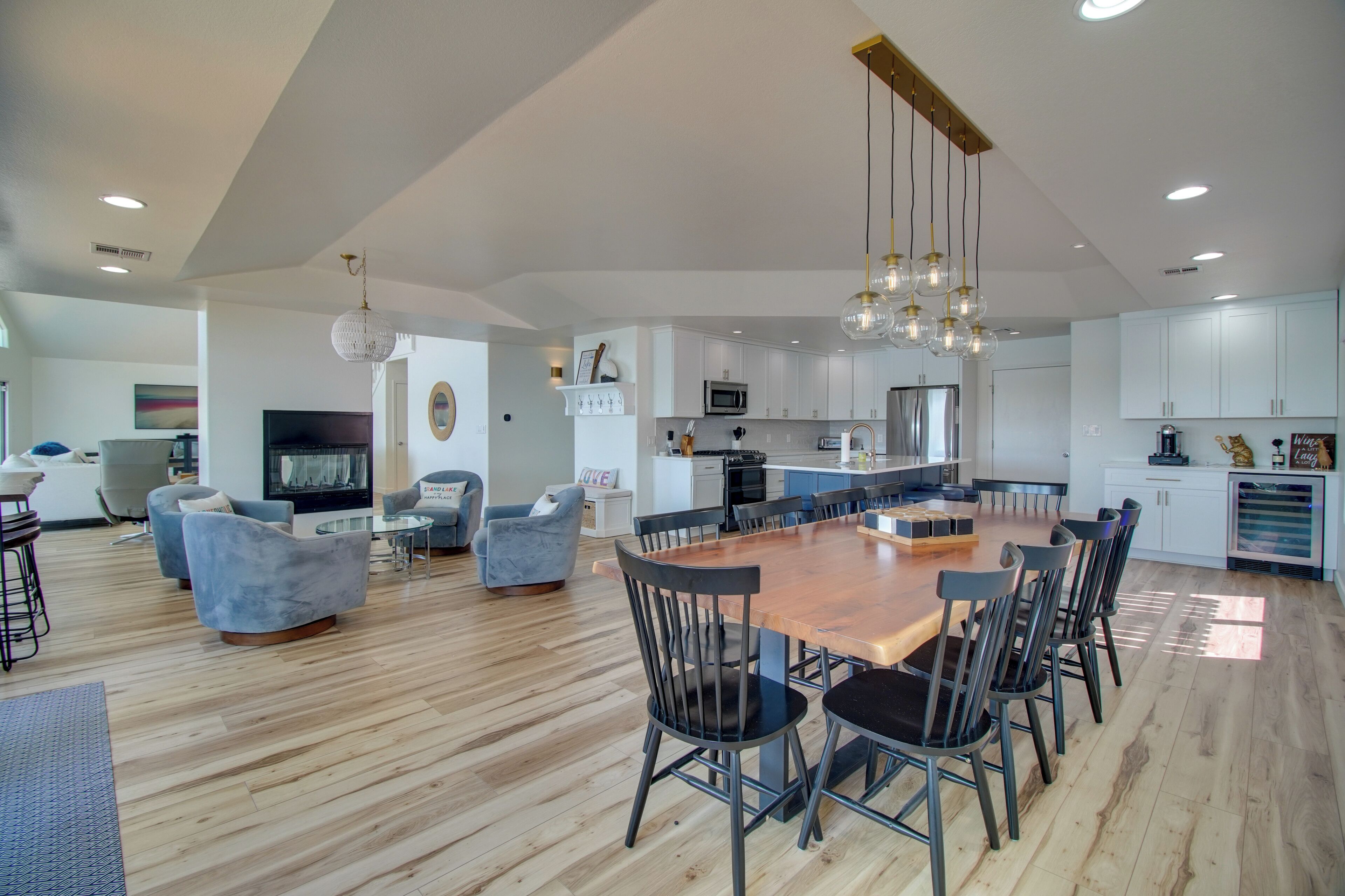A spacious living area with a wooden dining table surrounded by chairs, a fireplace, and a television.