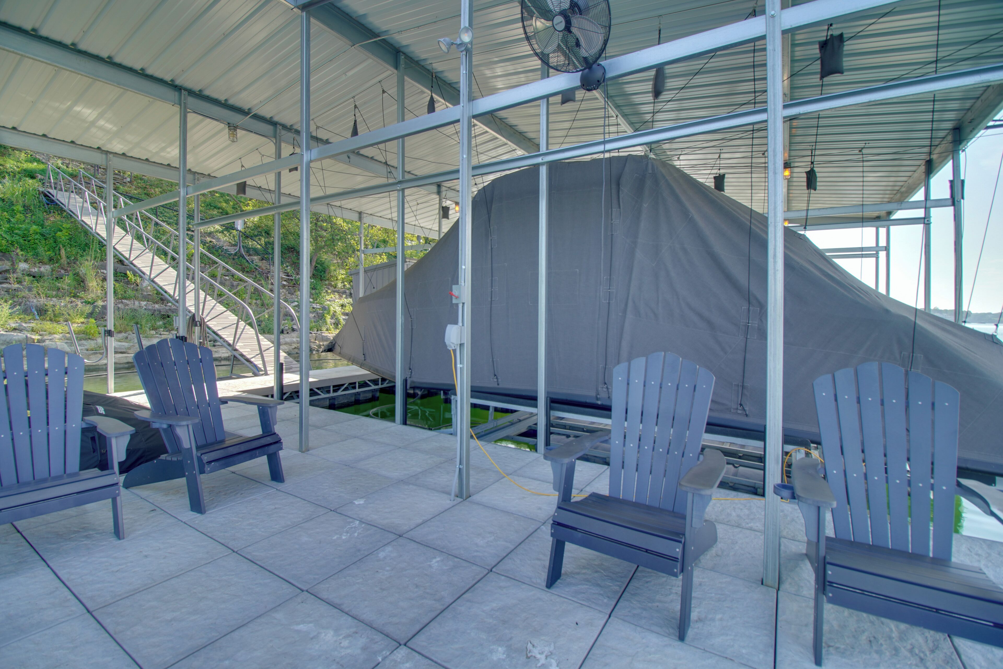 A covered outdoor seating area with Adirondack chairs and a covered structure.