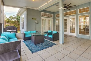 A covered patio with wicker furniture, a glass table, and a ceiling fan. - Pet-friendly Panama City Beach Home Near Beaches! (Panama City Beach)