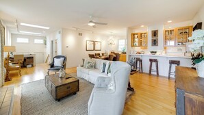 A spacious living room with a large sofa, a coffee table, and a dining area with a kitchen in the background. - 1 Mi to Indiana Dunes NP: Spacious Gary Home! (Gary)