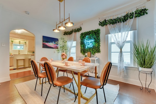A dining area with a white table, brown chairs, and a neon sign reading "Niagara Falls". - Niagara Falls by Day, Arcade Games by Night (Niagara Falls)