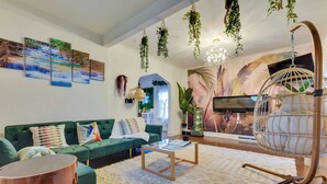 Ein modernes Wohnzimmer mit einem grünen Sofa, einem Couchtisch und einem Hängekorbstuhl.
