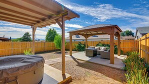 Un patio techado al aire libre con una parrilla, zona de estar y cerramiento de madera.