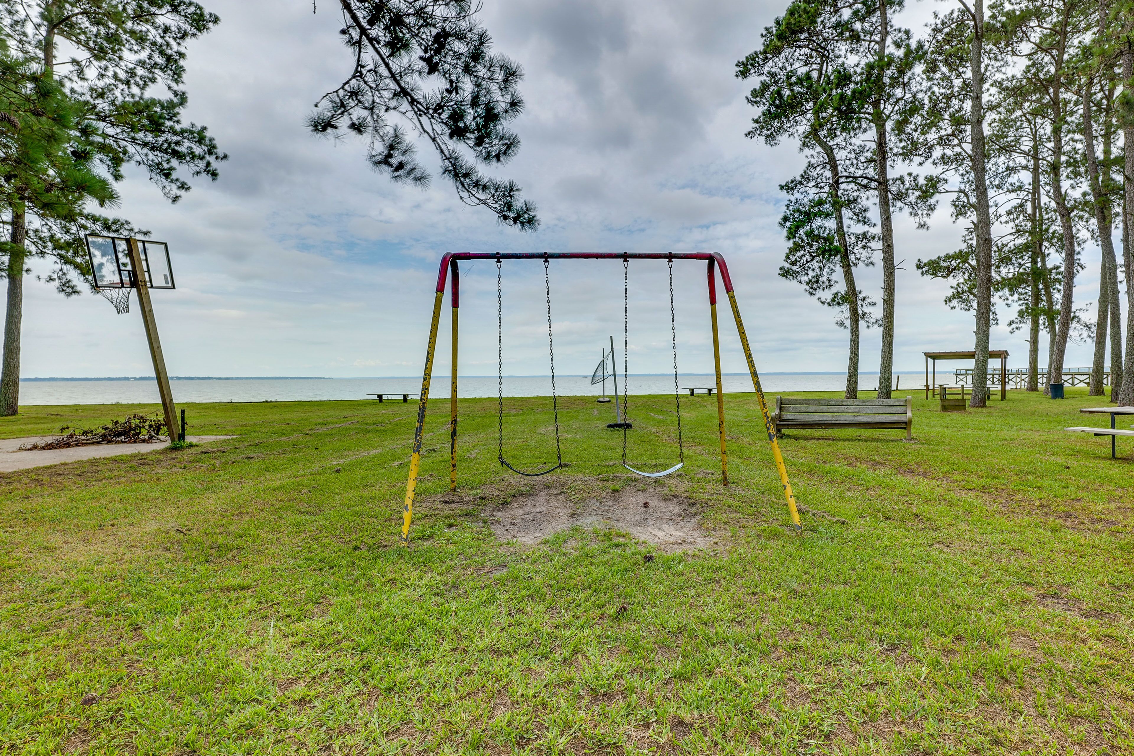 A park with a swing set, a bench, and a picnic table.